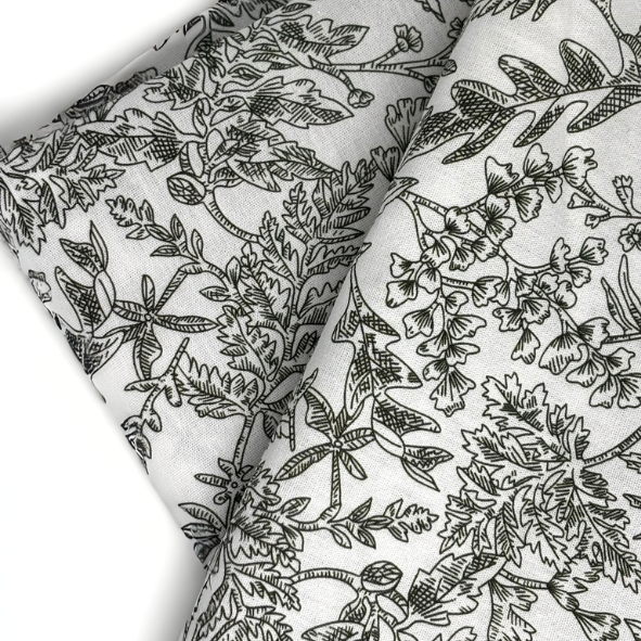 Gefalteter Baumwollstoff mit feinem floralen Linienmuster in Dunkelgrün auf naturweißem Grund, detailreiche Nahaufnahme – elegantes, botanisch inspiriertes Textildesign für stilvolle Wohnaccessoires von Fraeulein Matilda.
