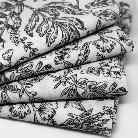 Zusammengelegter Stoff mit schwarzem botanischem Linienmuster auf weißem Grund, Nahaufnahme der Struktur – stilvolles Naturdesign für Wohntextilien im zeitlosen, ruhigen Look von Fraeulein Matilda.