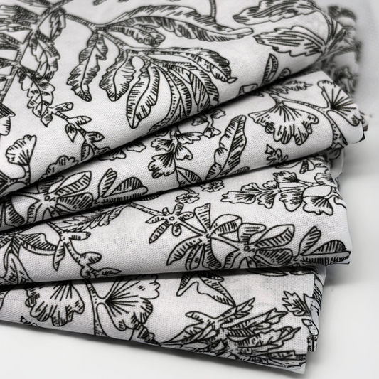 Zusammengelegter Stoff mit schwarzem botanischem Linienmuster auf weißem Grund, Nahaufnahme der Struktur – stilvolles Naturdesign für Wohntextilien im zeitlosen, ruhigen Look von Fraeulein Matilda.